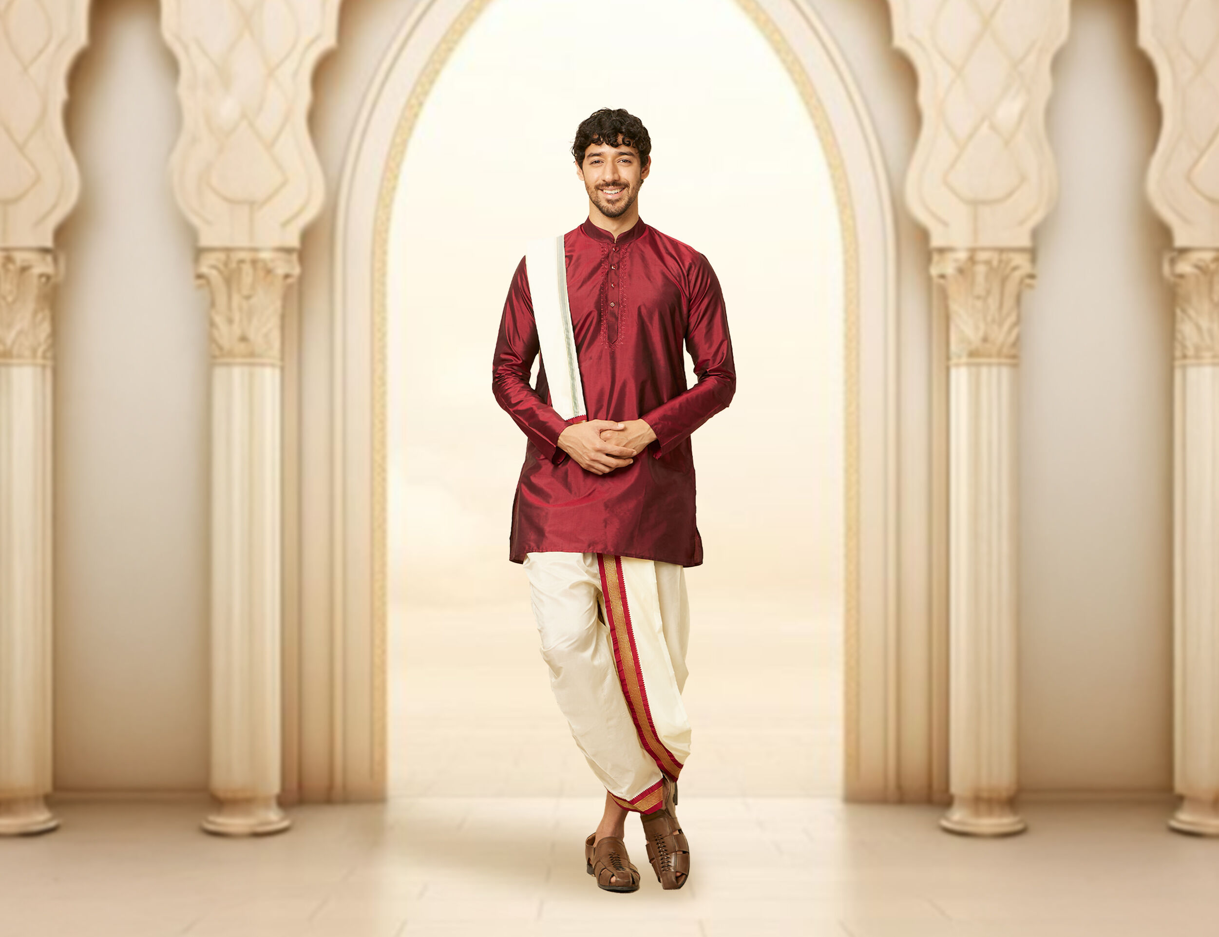 A groom in red kurta dhoti for wedding reception